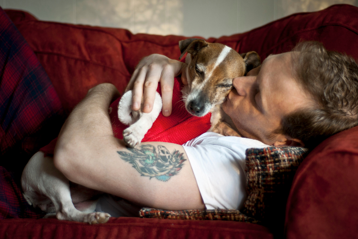 man holding dog on the couch