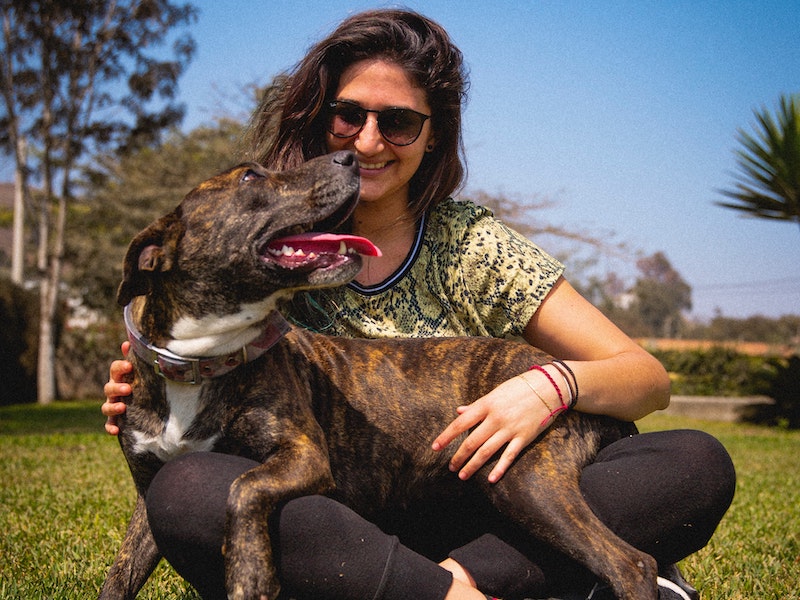 Women with a happy dog due to positive mental health practices